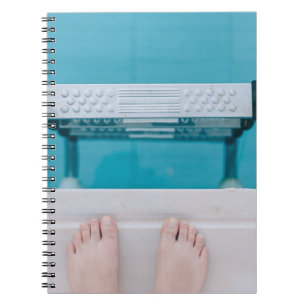 Person standing on swimming pool ladder notebook
