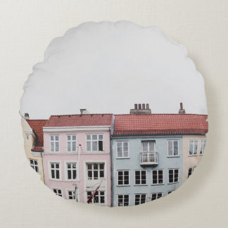 PERSON TAKING PICTURE OF STRUCTURES ROUND PILLOW