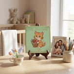 Personalized Baby Keepsake | Copper Gold Spring Ca Tile<br><div class="desc">Capture the magic of a first spring with this elegant personalized ceramic tile! Featuring a charming ginger cat with a flower basket on a beautiful, fresh green background, framed in a warm copper-gold printed border. This high-quality keepsake is originally AI-generated and meticulously hand-refined for a premium look. Please note: The...</div>
