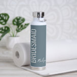 Personalized Bridesmaid Dusty Blue White Script Water Bottle<br><div class="desc">Surprise your wedding gal pals with this Personalized Bridesmaid Dusty Blue White Script Water Bottle. It is modern minimalist designed with a customizable blue background. The text is "bridesmaid" in big white lettering vertical on left front side. Name is in matching trendy hand lettered script on on right lower area....</div>