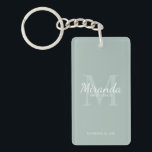 Personalized Bridesmaid's Monogram and Name Keychain<br><div class="desc">Personalized Bridesmaids Gifts features personalized bridesmaid's name in white classic script font style and monogram in sage green classic serif font style as background with title and wedding date in white classic serif font style on sage green background. Also perfect for maid of honour, flower girl, mother of the bride...</div>