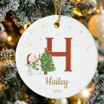 Personalized Initial Letter Custom Name Snowman Ceramic Ornament<br><div class="desc">Add a touch of personal charm to your tree with this Personalized Initial Letter Christmas Ornament. Featuring a joyful snowman decorating a Christmas tree beside a bold monogram initial, this ornament brings together festive cheer and timeless style. Perfect for families, kids, couples, or anyone who loves personalized holiday décor, this...</div>