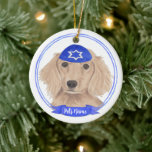 Personalized Red English Dachshund Dog Hanukkah Ceramic Ornament<br><div class="desc">Celebrate your favourite mensch on a bench with personalized ornament! This design features a sweet illustration of a red english long haired dachshund dog with a blue and white yarmulke. For the most thoughtful gifts, pair it with another item from my collection! To see more work and learn about this...</div>