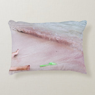 Person's foot beside green shovel on seashore accent pillow