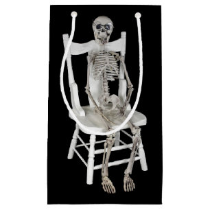 Petit Sac Cadeau squelette assis sur une chaise blanche