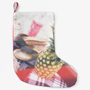 Petite Chaussette De Noël Ananas à côté du téléphone et du haut-parleur