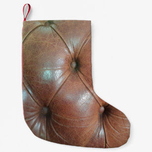Petite Chaussette De Noël Lumière sur la surface du canapé en cuir marron, t