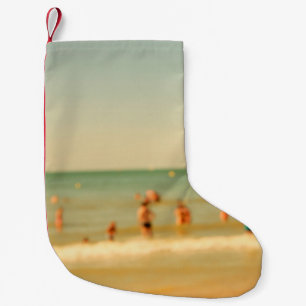 Petite Chaussette De Noël Photo de plage floue avec bokeh. Les gens se relax