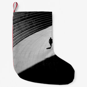 PETITE CHAUSSETTE DE NOËL SILHOUETTE D'UNE PERSONNE MARCHANT SUR LE BÉTON GR