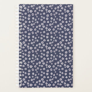 Petites fleurs blanches sur un planificateur bleu