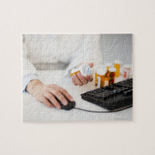 Pharmacist with pill bottles at computer jigsaw puzzle