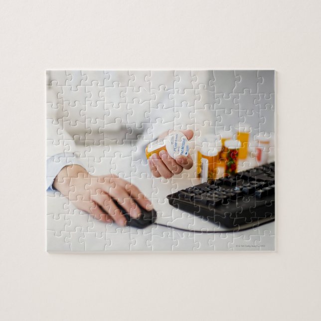 Pharmacist with pill bottles at computer jigsaw puzzle (Horizontal)