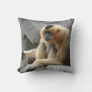 Photo of Orange and Black Gibbon Relaxing on Cliff Throw Pillow