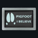 Pigfoot - I Believe Rectangular Belt Buckle<br><div class="desc">Maybe it is just a typo, or a mutant Sasquatch; or maybe some parts of the world are inhabited by another class of cryptid animals. A simple feral hog's footprint along with text reading, "PIGFOOT." Customizable text reading, "I BELIEVE" also appears. Who knows what out there running around in the...</div>