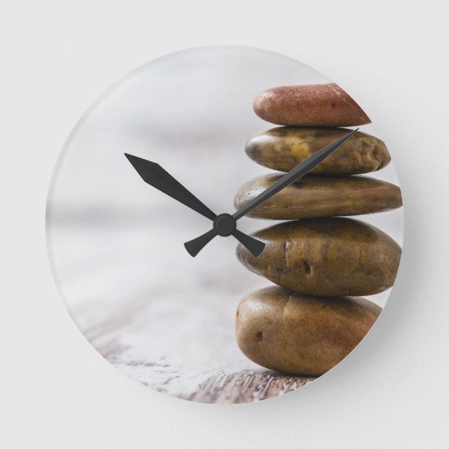 Pile of dark coloured stones on white background round clock (Front)