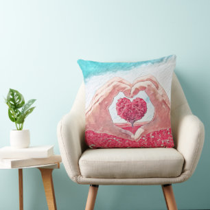 Pillow with heart in between open heart hands