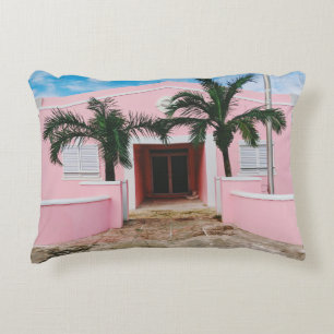 Pink and white concrete house near green trees und accent pillow