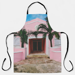 Pink and white concrete house near green trees und apron