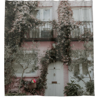 PINK AND WHITE PAINTED HOUSE COVERED WITH PLANTS A