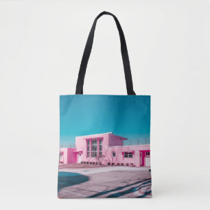 Pink concrete building under clear blue sky tote bag