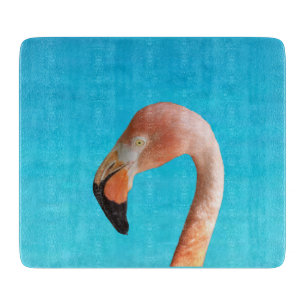 Pink flamingo face against blue water on a cutting board