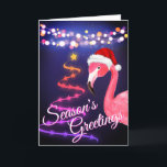 Pink Flamingo Festive Tropical Beach Christmas Holiday Card<br><div class="desc">This Season's Greetings tropical beach Christmas greeting card features a pink flamingo wearing a red and white Santa hat.  There are festive holiday string lights and a Ribbon and Stars Christmas tree.  Inside Greeting ~ "Warmest Wishes From Our Holiday Paradise To Yours".   ^</div>