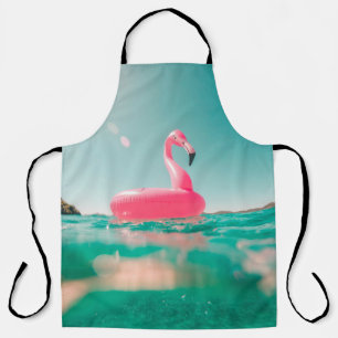 Pink flamingo swim ring on body of water in summer apron