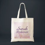 Pink Floral Bridesmaid Wedding Welcome Tote Bag<br><div class="desc">Greet your bridesmaids with a beautiful and practical personalized pink floral bridesmaid tote bag. The background is a soft watercolor pink floral. Her name and the title bridesmaid is below. Both name and bridesmaid are written in a pretty purple modern script font. Both words can be easily customized. Bridesmaid can...</div>