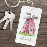 Pink Initial Name Monogram Golf Keychain<br><div class="desc">This cute monogram keychain features a stylish pink watercolor golf bag filled with clubs, surrounded by a touch of green grass. The design cleverly incorporates a simple serif font initial monogram on the bag, seamlessly blending into the design. Below the monogram, the full name is elegantly displayed in script typography,...</div>