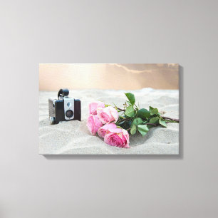 pink roses in sand with retro camera canvas print