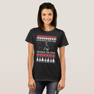 Pinscher de dobermann par le T-shirt de neige