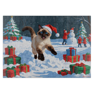 Planche À Découper Chat siamois courant dans la neige avec un chapeau