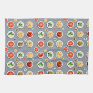 Plates of tomato basil and pasta on a gray kitchen towel