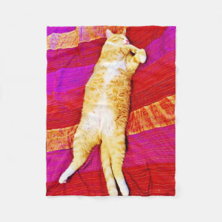 Polaire Le chaton orange dort sur une couverture en toison