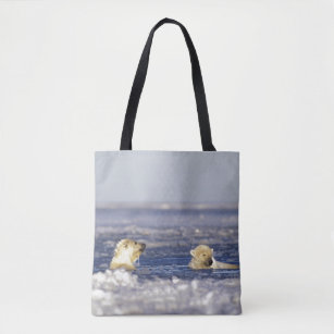 Polar bear cubs playing in pack ice of the tote bag