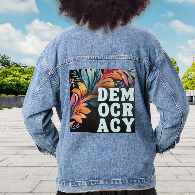 Politique de déclaration colorée rétro Groovy Démo (A stylish denim jacket with 'Democracy' in capital letters on a decorative leafy back panel)