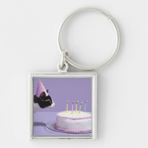 Porte-clés Casquette de port d'anniversaire de chat soufflant