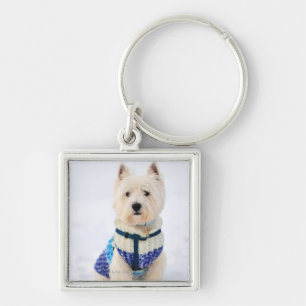 Porte-clés Chien blanc dans des vêtements dans la neige