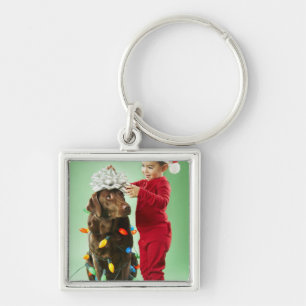 Porte-clés Jeune garçon enroulant des lumières de Noël autour