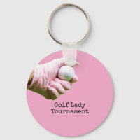 Lady golfer tient une balle de golf sur fond de pi