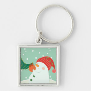 Porte-clés Un bonhomme de neige accrochant un ornement sur un
