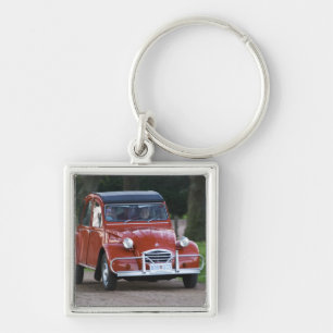 Porte-clés Une vieille voiture rouge Citroen 2CV avec une fem