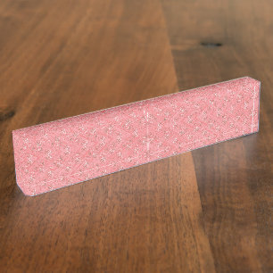 Porte-nom Un tapis aux motifs rouges et roses présente un dé
