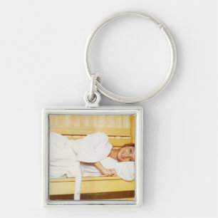 Portrait of a young woman lying in a sauna keychain