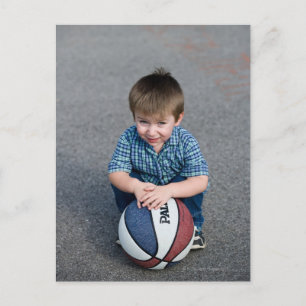 Portrait of boy with basketball outdoors postcard