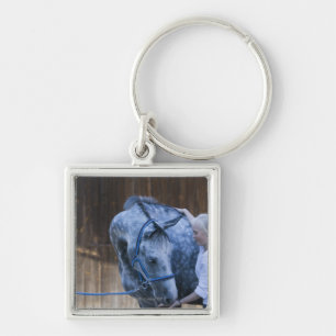 portrait of young girl holding white horse keychain