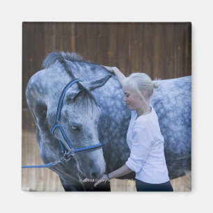 portrait of young girl holding white horse magnet