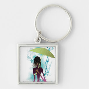 Portrait of young woman holding purse and umbrella keychain