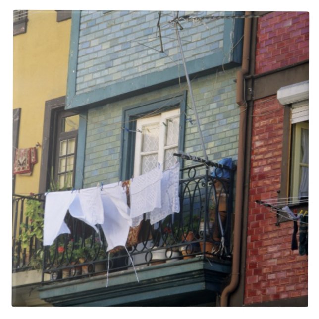 Portugal, Oporto (Porto). Woman hanging laundry Tile (Front)