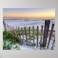 Une clôture de plage au coucher du soleil